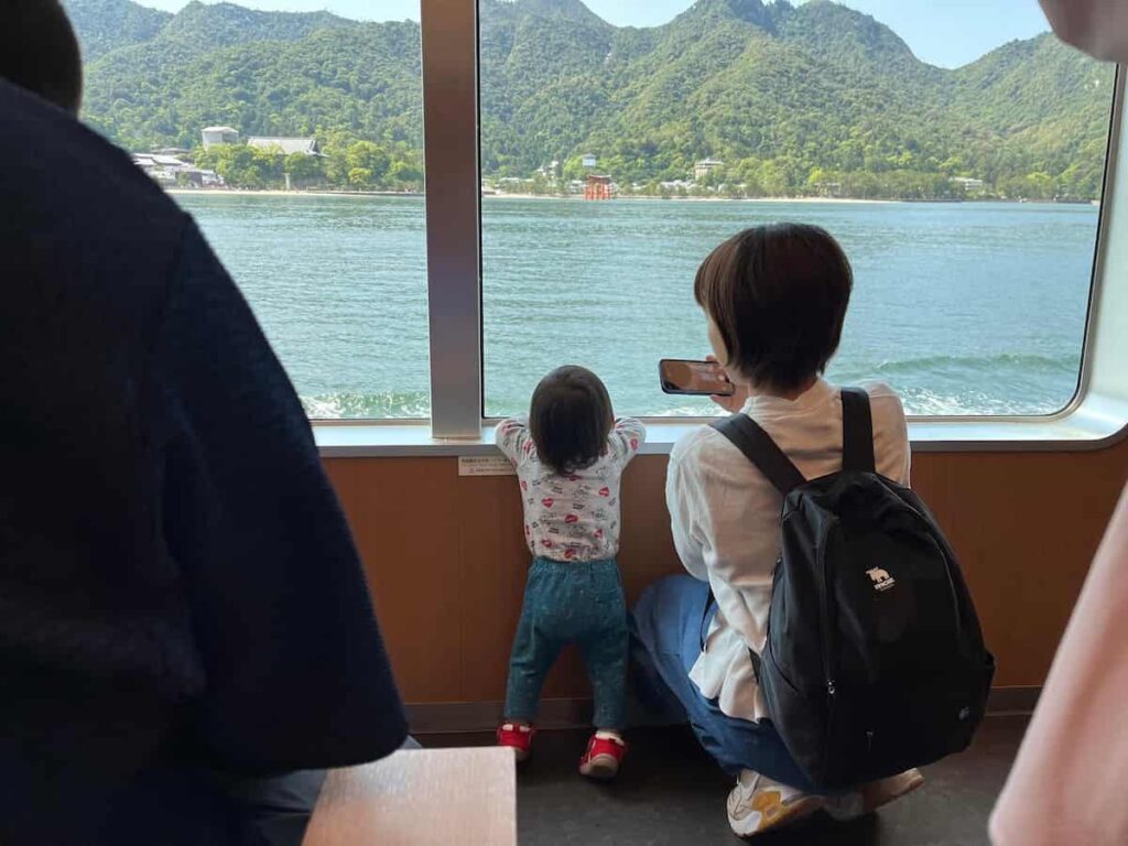 【厳島神社&錦帯橋旅log】山口と広島の名所を巡る旅|じーじとばーばとの家族旅行第4弾 2025.5.31-6.1 3 フェリーから厳島神社の鳥居を見つめる子供の画像