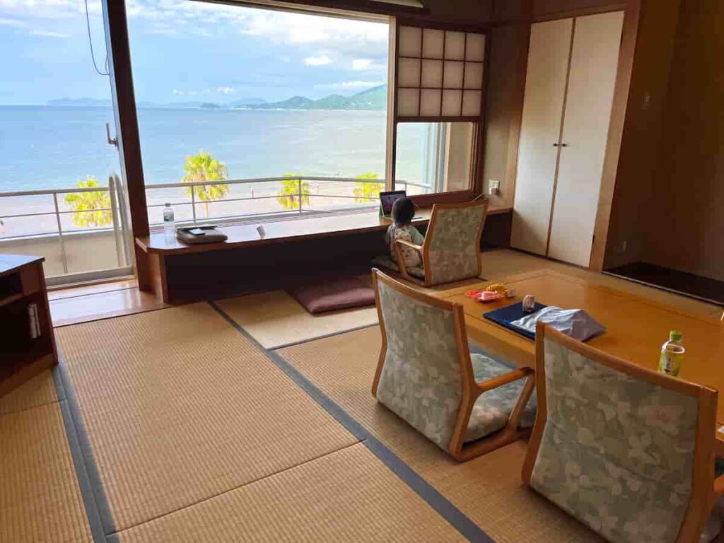 【唐津旅行log】唐津シーサイドホテル|鏡山展望台を巡るオーシャンビューの旅 2025.8.23-24 6 部屋の窓際でくつろぐ娘の写真