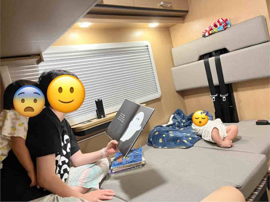 【キャンピングカー旅log】大分・熊本を巡る3泊4日ドライブ旅行 2026.8.25-27 13 キャンピングカーの中で絵本を読んでいる光景